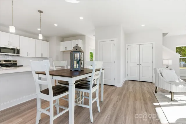 a kitchen with kitchen island wooden floors cabinets and stainless steel appliances
