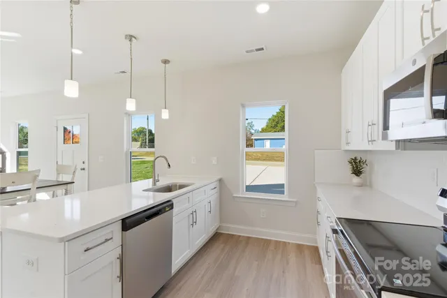 a kitchen with a sink window and wooden floor