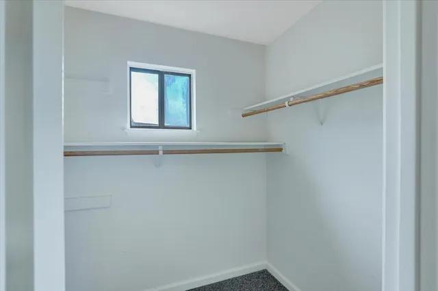 a view of a small space with wooden floor and a window