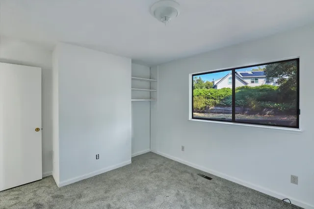 a view of a room with a large window and front door