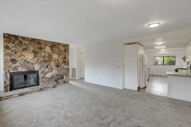 a view of an empty room with a fireplace and a window