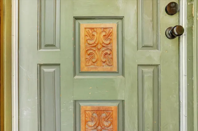a view of an empty room with kitchen and a window