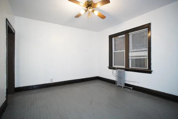 an empty room with a window and a ceiling fan