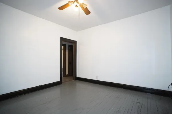 an empty room with a ceiling fan and a window