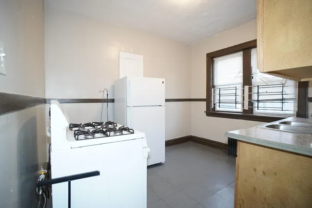 a kitchen with a refrigerator a stove a sink and a window