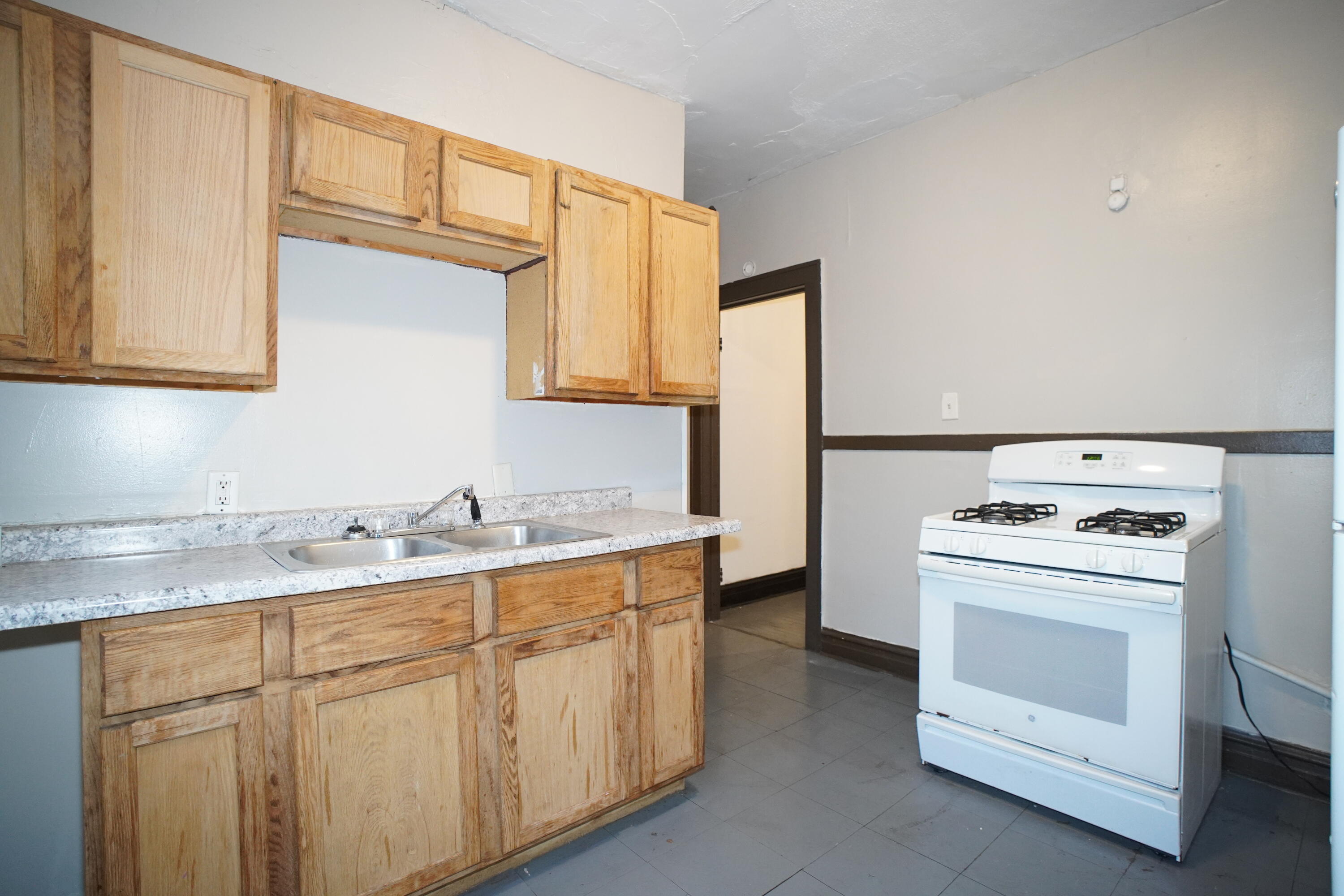 1166 Connecticut Street, Unit 6 Gary, IN 46407 - Photo 5 of 10 a kitchen with cabinets appliances a sink and a window