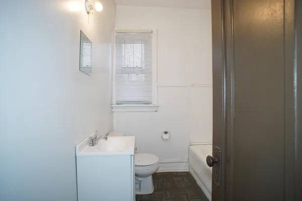 a bathroom with a toilet a sink and mirror