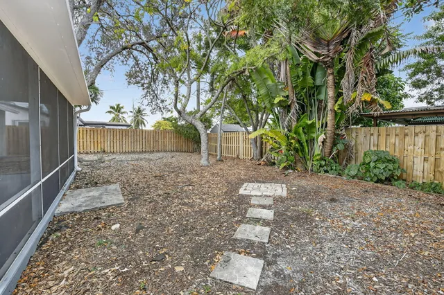 a view of a yard with plants and trees