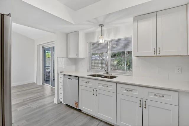 a kitchen with appliances cabinets and a wooden floor