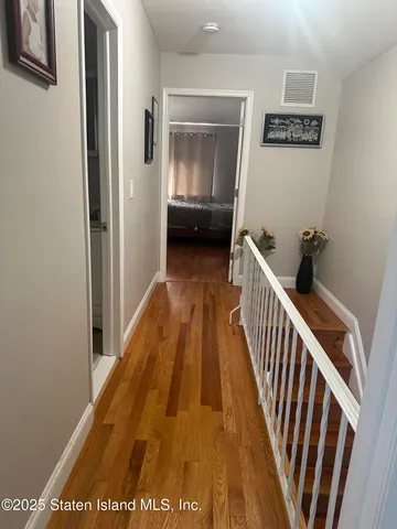 a view of a hallway with wooden floor and stairs