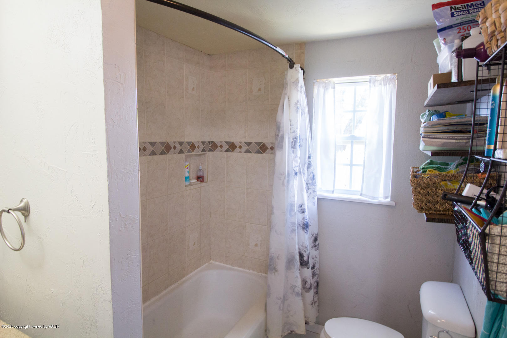 313 Southwest 38th Avenue Amarillo, TX 79110 - Photo 15 of 22 a bathroom with a shower curtain and a window