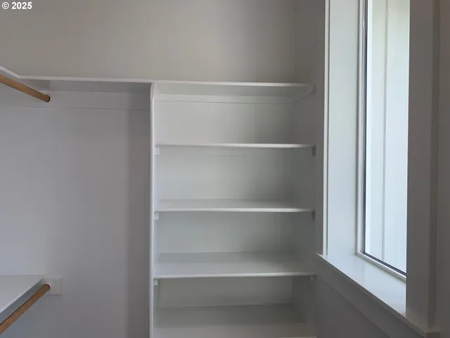 a view of walk in closet with empty racks