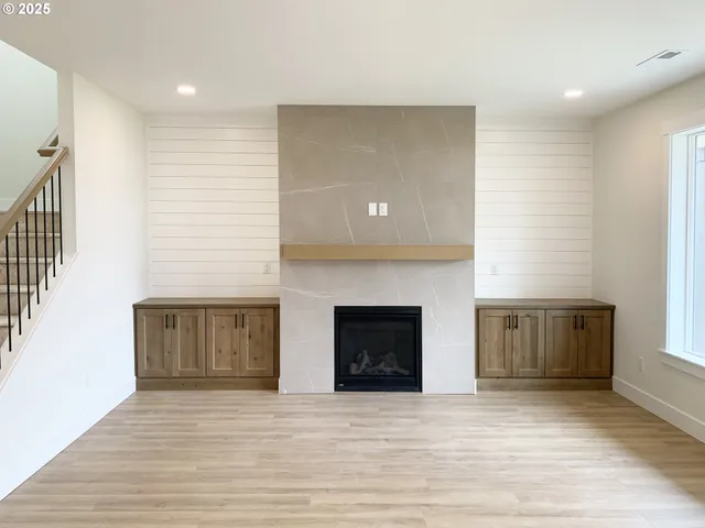 a view of an empty room with a fireplace and a window