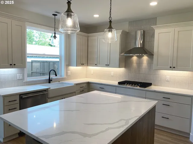 a kitchen with kitchen island a sink stainless steel appliances and window