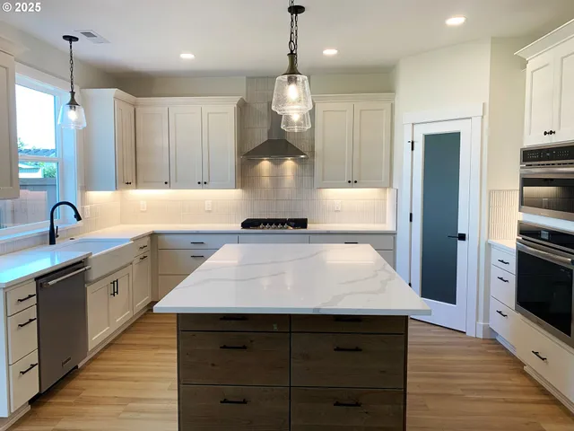 a kitchen with kitchen island granite countertop a stove a sink and a refrigerator