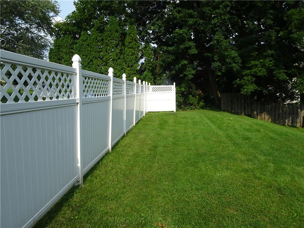 A well-kept lawn bordered by a pristine white fence creates a serene outdoor space.