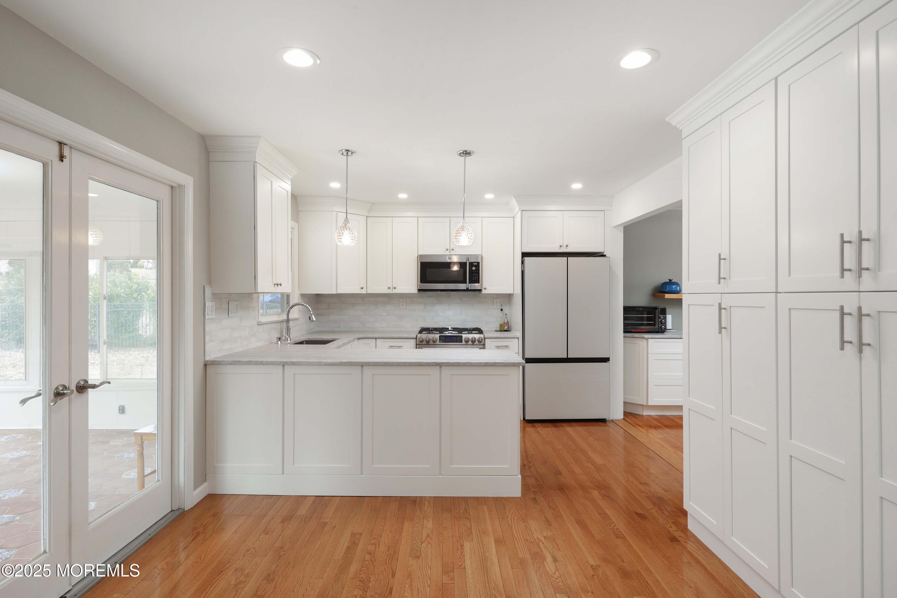 6 Hawthorne Road Red Bank, NJ 07701 - Photo 13 of 40 a kitchen with stainless steel appliances granite countertop a refrigerator a sink a stove and white cabinets with wooden floor