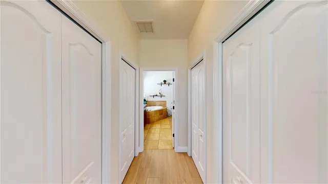 a view of a hallway with white walls and wooden floor