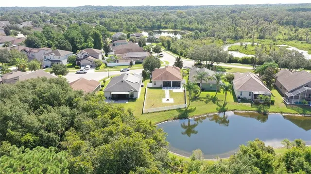an aerial view of residential houses with outdoor space and a lake view