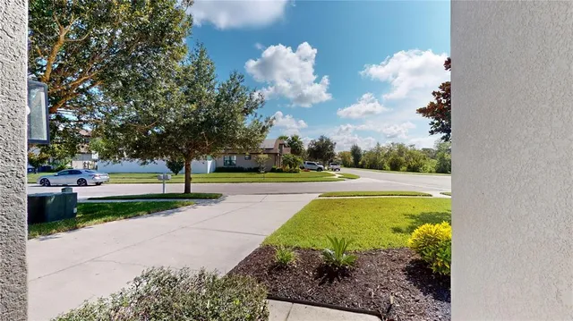 an aerial view of residential houses with outdoor space and trees