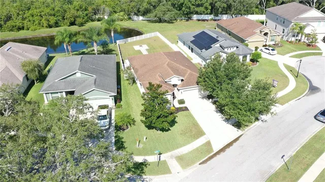 an aerial view of a house with a yard and lake view
