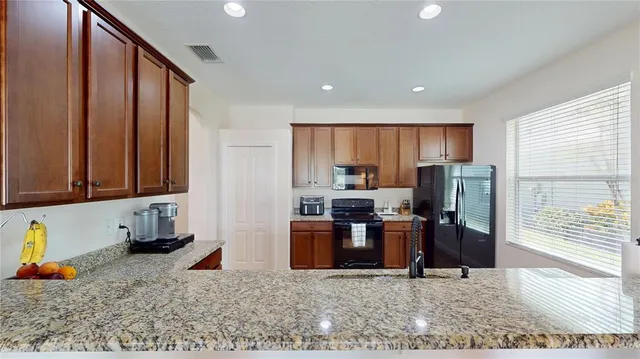 a kitchen with stainless steel appliances granite countertop a refrigerator sink and stove