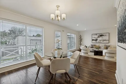 a view of a dining room with furniture a chandelier and wooden floor
