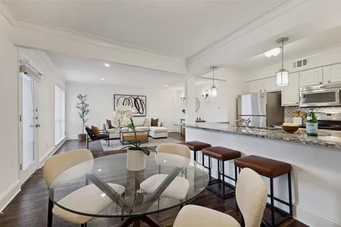 a living room with lots of furniture and kitchen view