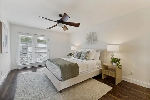 a spacious bedroom with a bed and wooden floor