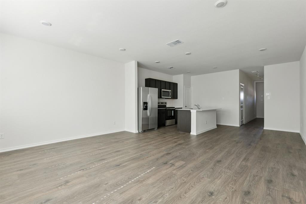 317 Clematis Street Princeton, TX 75407 - Photo 5 of 38 Unfurnished living room with dark wood-style flooring and recessed lighting