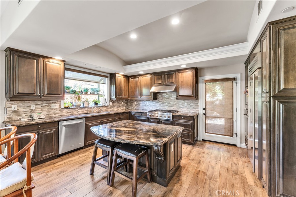 4117 Mt Baldy Road Claremont, CA 91711 - Photo 27 of 75 a kitchen with granite countertop a stove a sink dishwasher a refrigerator and wooden cabinets with wooden floor