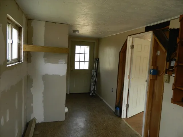 a view of hallway with window and wooden cabinets