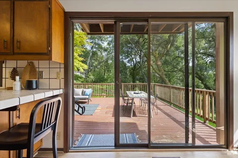 a view of a balcony with floor to ceiling windows and wooden floor