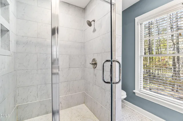 a bathroom with a granite countertop double vanity and a mirror