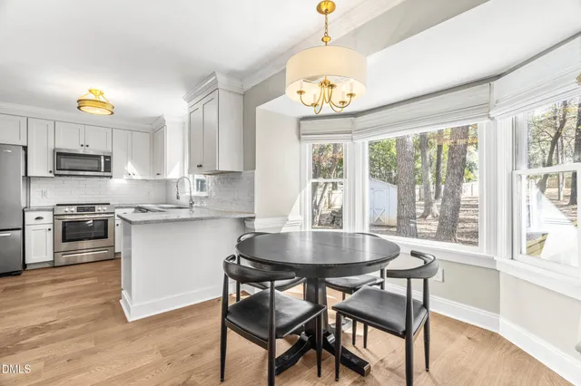 an empty room with windows and fireplace