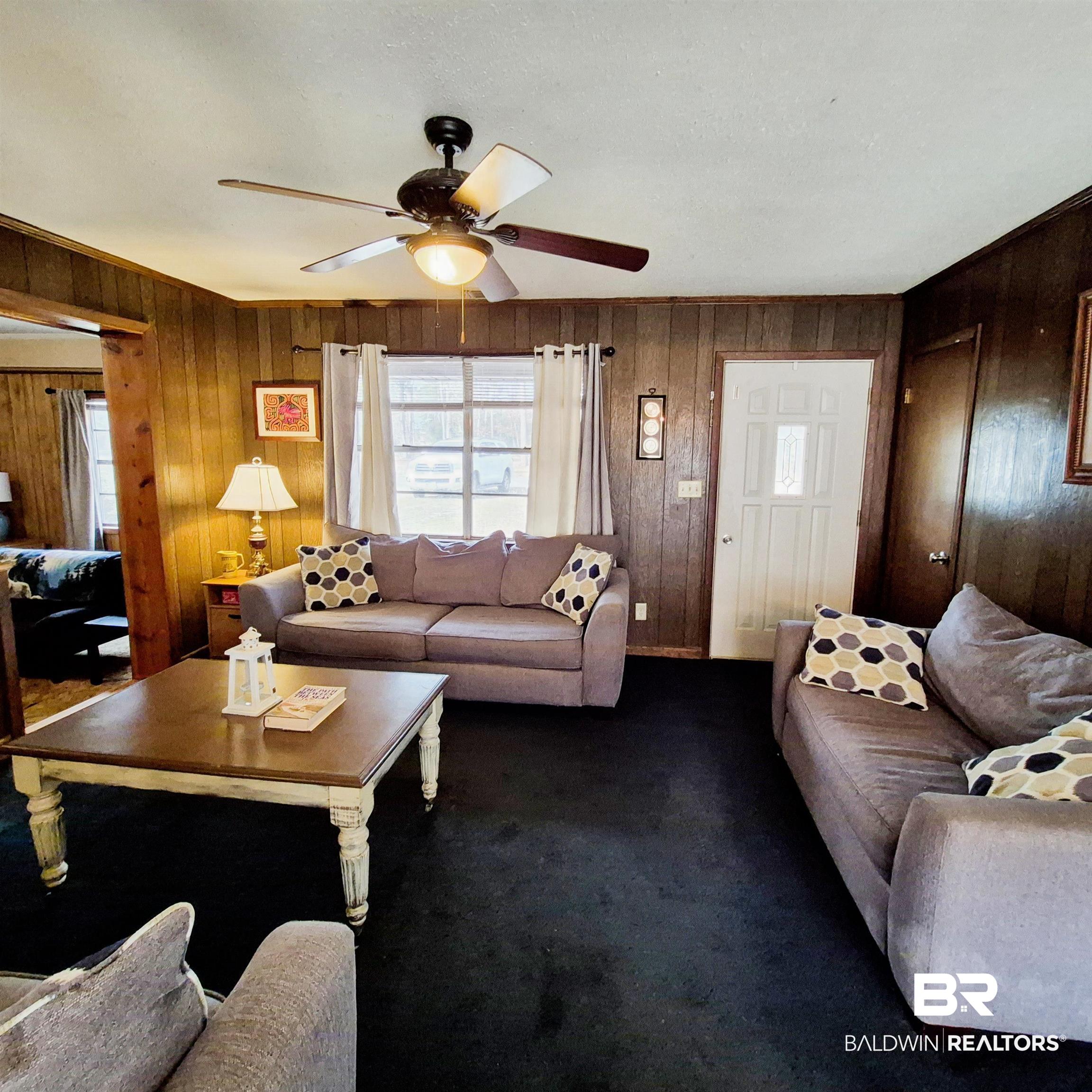 491 Forrest Avenue Castleberry, AL 36432 - Photo 3 of 33 Living area with carpet floors, a ceiling fan, and wooden walls