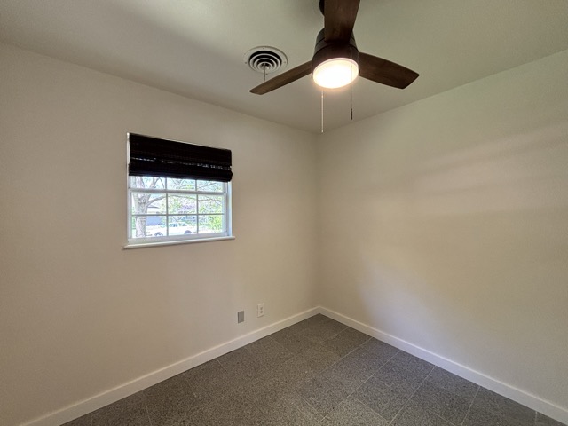 6303 Brookside Drive Austin, TX 78723 - Photo 22 of 26 an empty room with a chandelier fan and windows