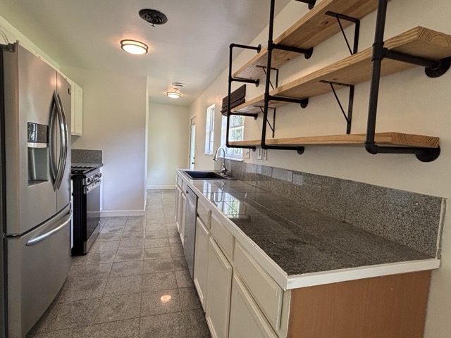 6303 Brookside Drive Austin, TX 78723 - Photo 10 of 26 a kitchen with stainless steel appliances granite countertop a sink and a refrigerator