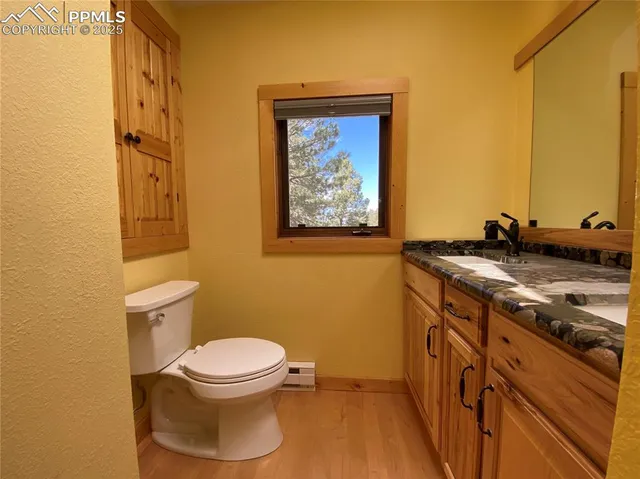 a bathroom with a granite countertop toilet and a sink