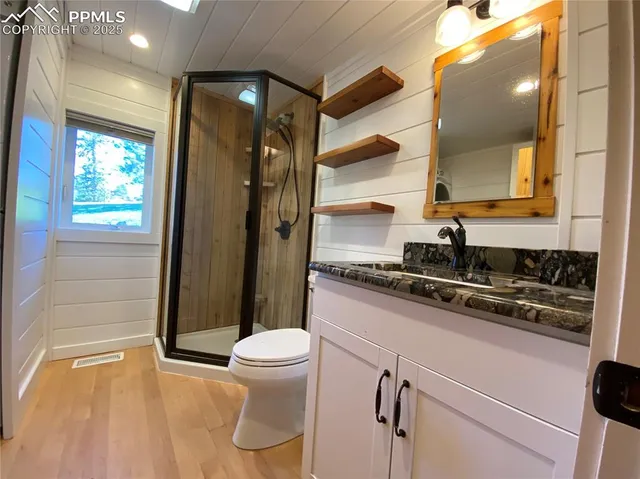 a bathroom with a granite countertop sink toilet and shower
