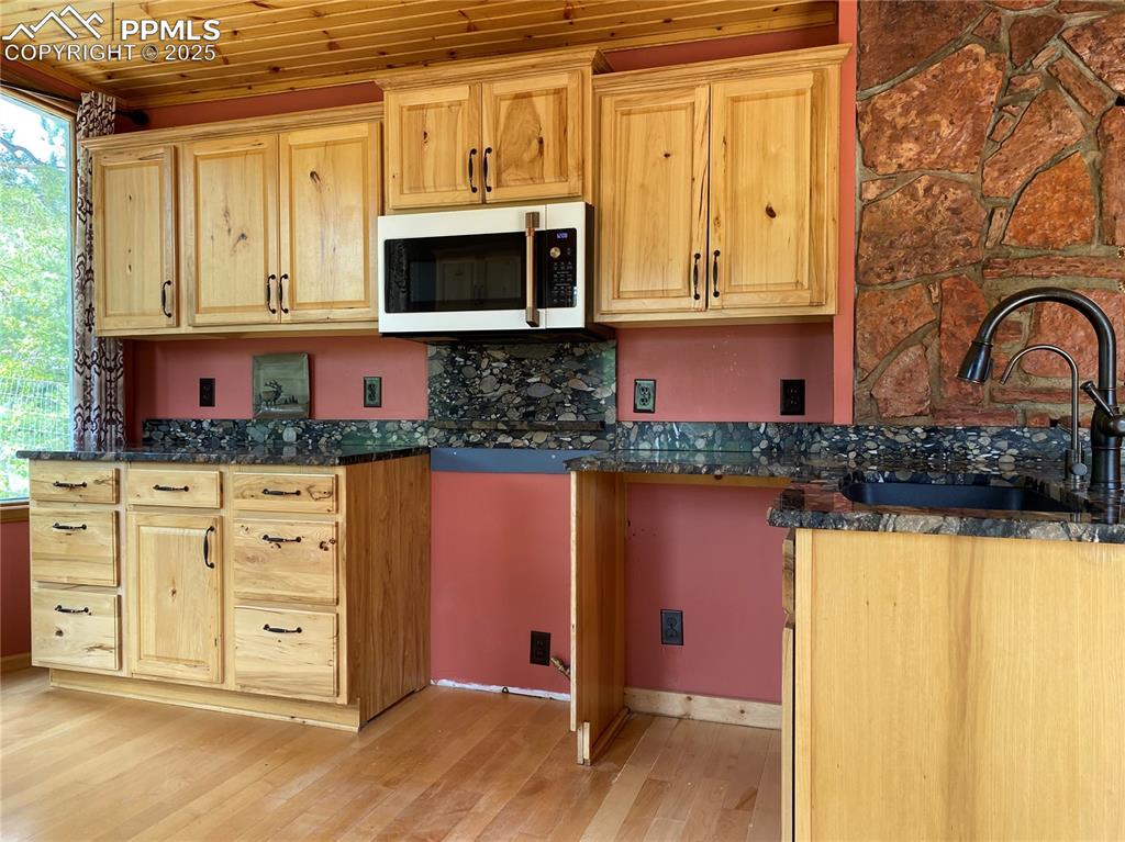 845 Markus Road Woodland Park, CO 80863 - Photo 21 of 40 a kitchen with stainless steel appliances granite countertop a stove a sink and a microwave