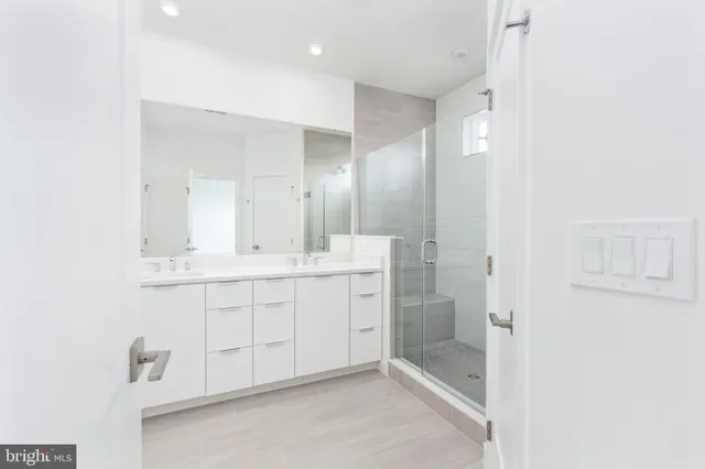 a bathroom with a double vanity sink mirror and shower