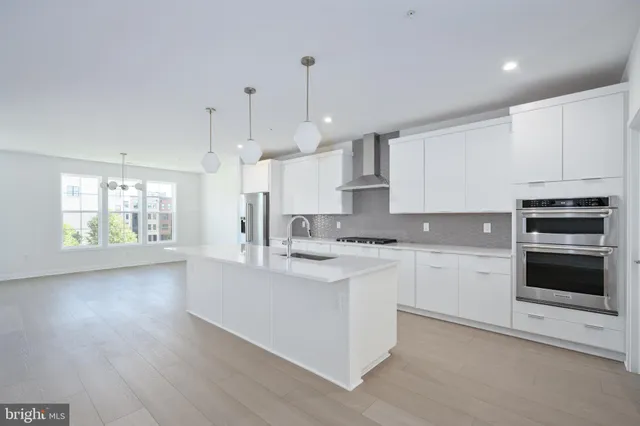 a large kitchen with cabinets wooden floor and stainless steel appliances