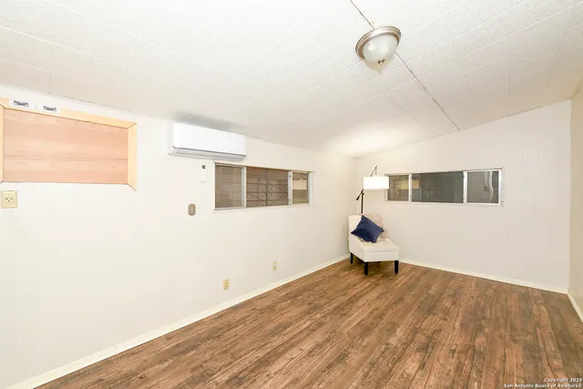 a room with wooden floor and windows
