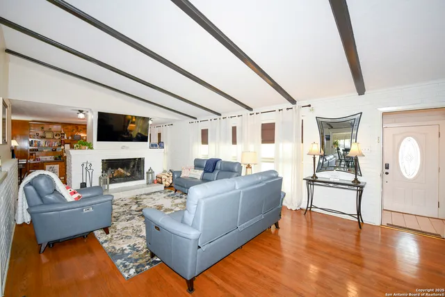 a living room with furniture a fireplace and a flat screen tv