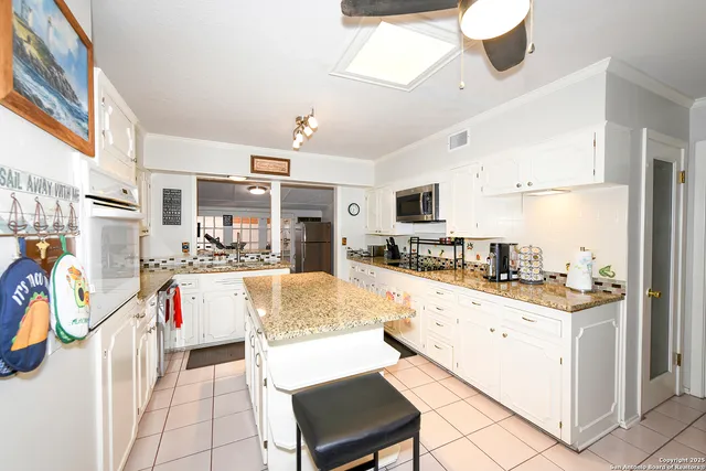 a living room with stainless steel appliances kitchen island granite countertop furniture and a kitchen view