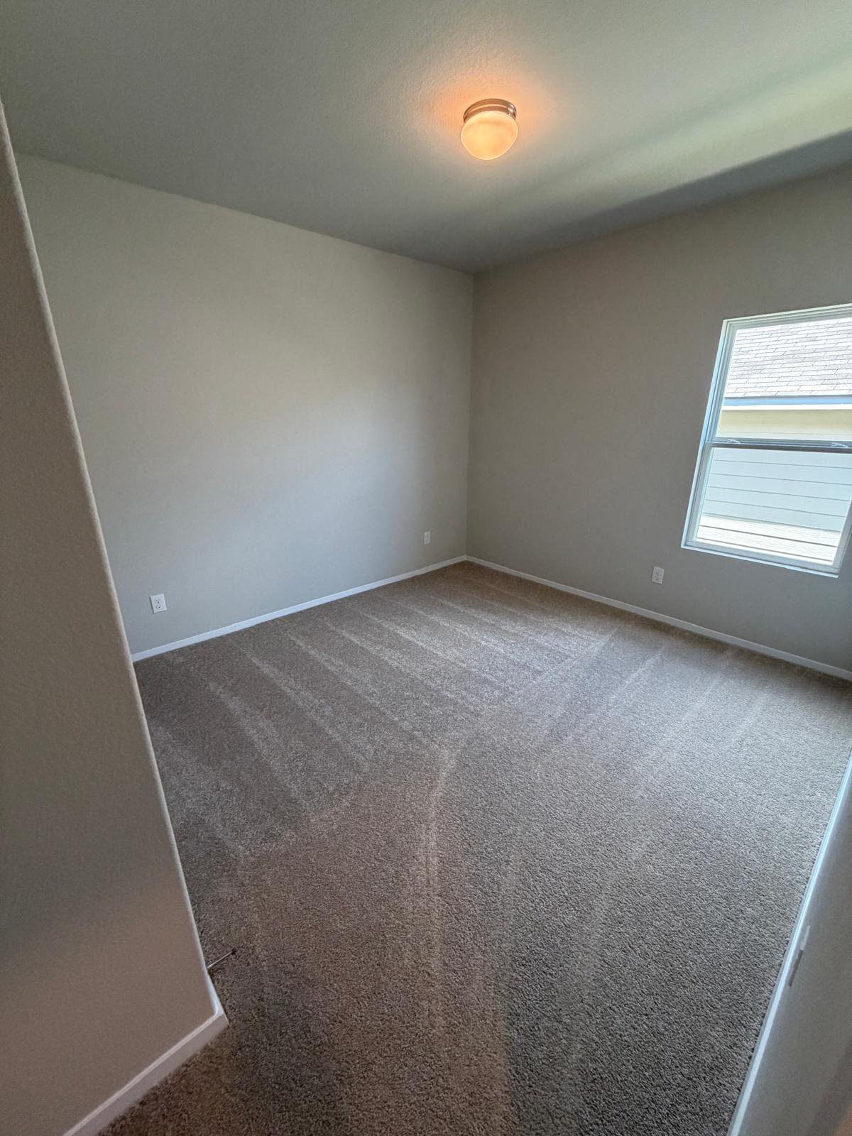 2612 Towy Road Manor, TX 78653 - Photo 11 of 35 A well-proportioned room with clean walls and fresh carpet awaits personal touches.