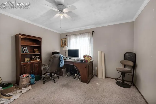 a view of a workspace with furniture and a window