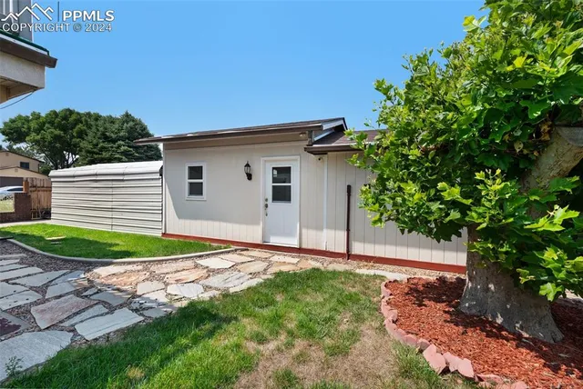 a backyard of a house with plants and entertaining space