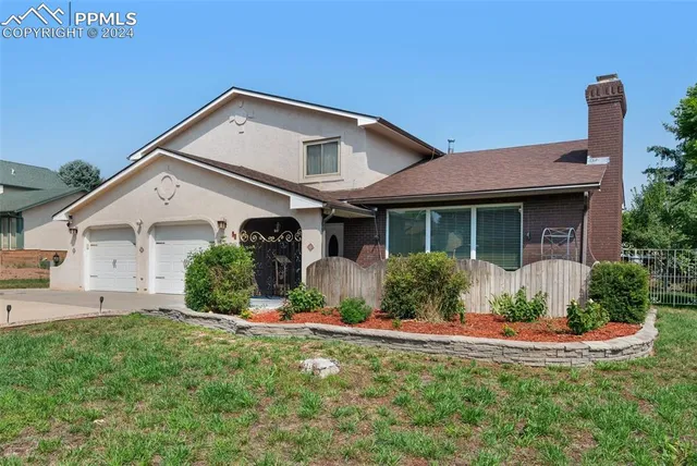 a front view of a house with a yard and potted plants